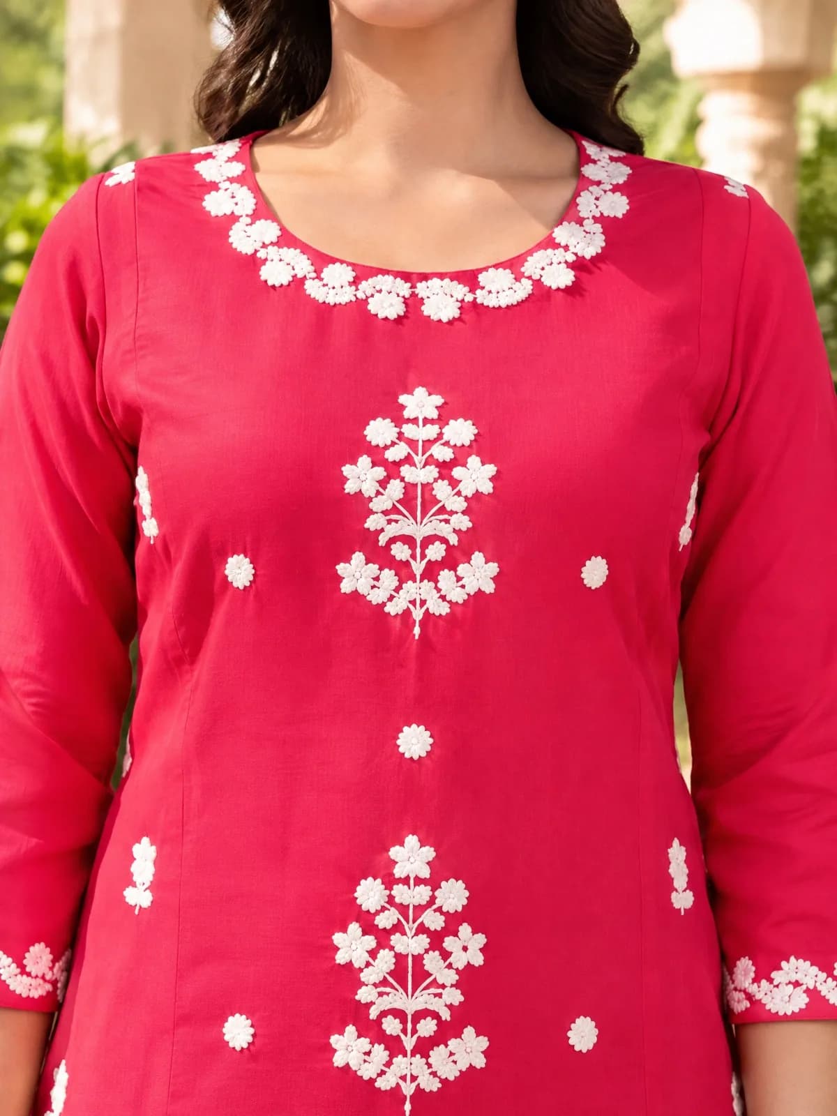 Close-up of white embroidery on a red kurta